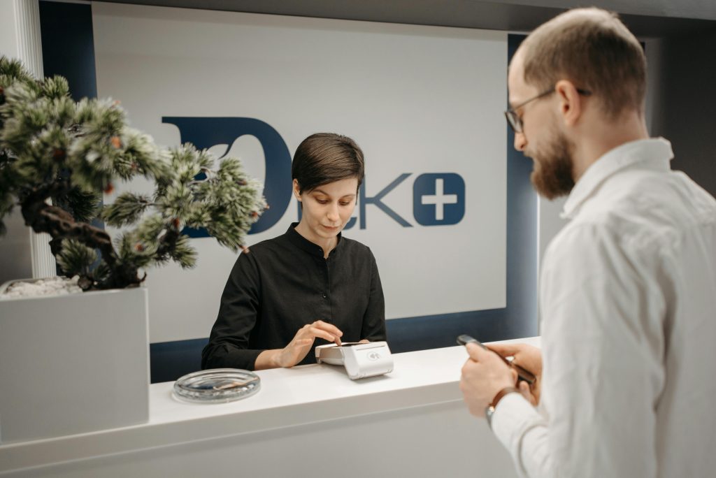 Customer makes a cashless payment at a clinic reception using wireless technology.